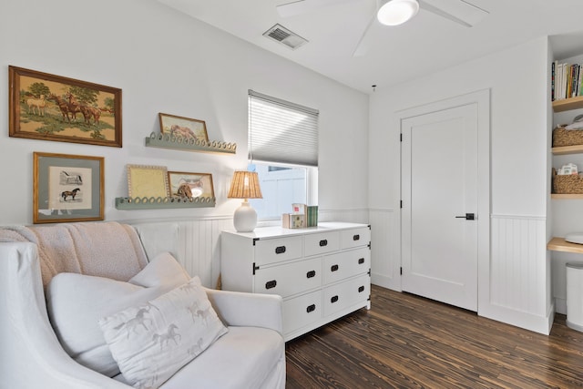 living area featuring ceiling fan and dark hardwood / wood-style flooring