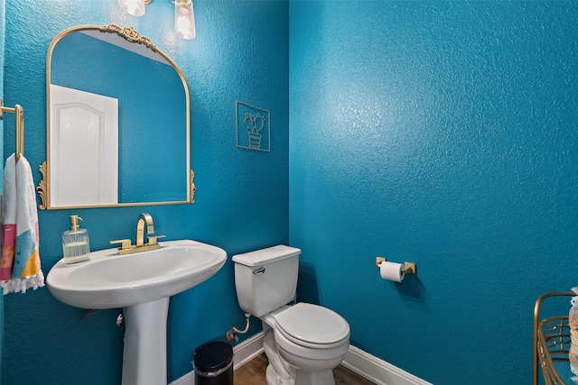 bathroom featuring wood-type flooring and toilet