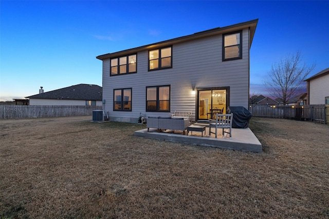 back house at dusk with a patio area, a lawn, central AC, and an outdoor hangout area