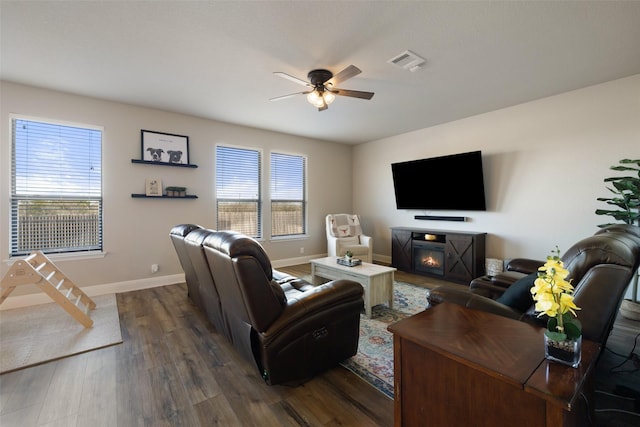 living room with ceiling fan, dark wood-type flooring, and a fireplace