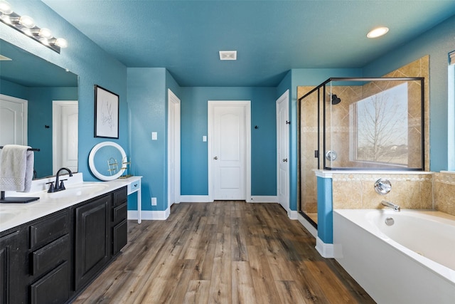 bathroom with hardwood / wood-style flooring, vanity, and independent shower and bath