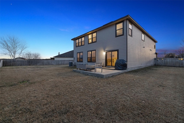 back house at dusk featuring cooling unit and a patio