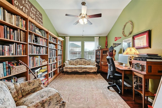 office with wall of books, a ceiling fan, vaulted ceiling, and wood finished floors