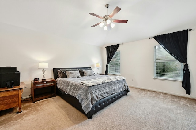 bedroom featuring vaulted ceiling, baseboards, a ceiling fan, and light colored carpet