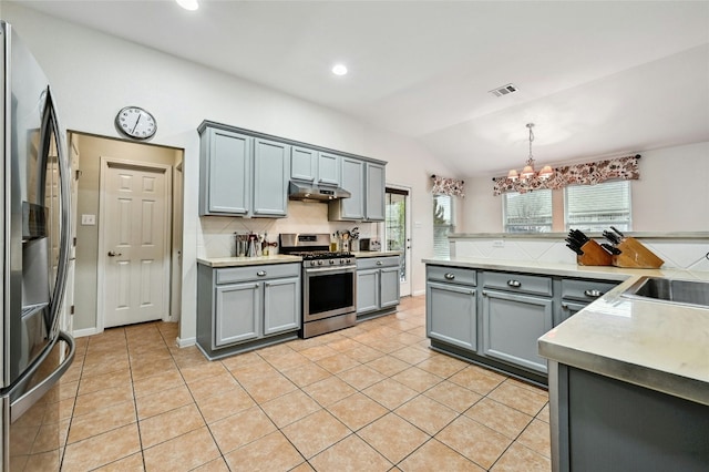 kitchen with appliances with stainless steel finishes, gray cabinets, light tile patterned flooring, and under cabinet range hood