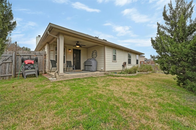 rear view of house featuring a yard, a patio area, fence, and a ceiling fan