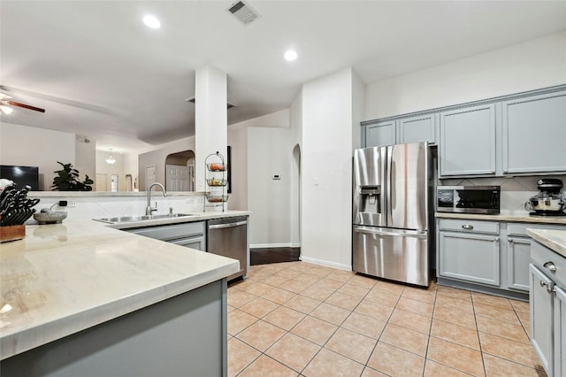 kitchen featuring light tile patterned floors, arched walkways, ceiling fan, visible vents, and appliances with stainless steel finishes