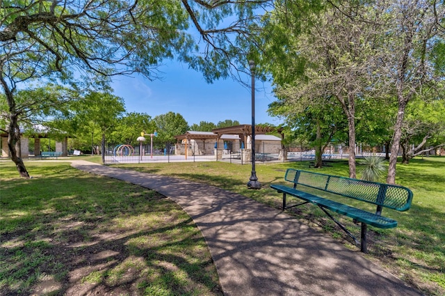 view of home's community with a yard and fence