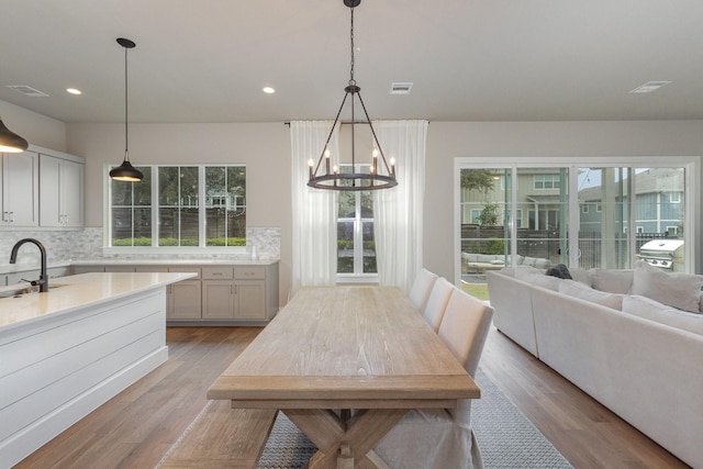 dining space featuring a wealth of natural light, an inviting chandelier, and light hardwood / wood-style flooring