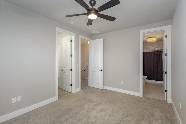 unfurnished bedroom featuring ceiling fan, a walk in closet, light colored carpet, and a closet