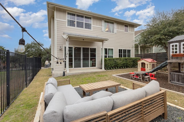 back of house with an outdoor living space, a playground, and a patio