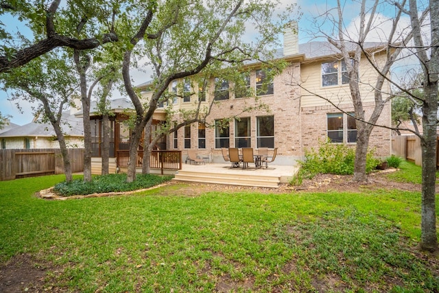 back of property with a wooden deck and a yard