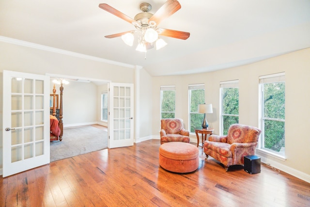 living area with hardwood / wood-style flooring, plenty of natural light, ceiling fan, and french doors