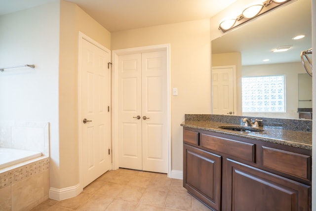 bathroom with vanity, tile patterned floors, and tiled bath