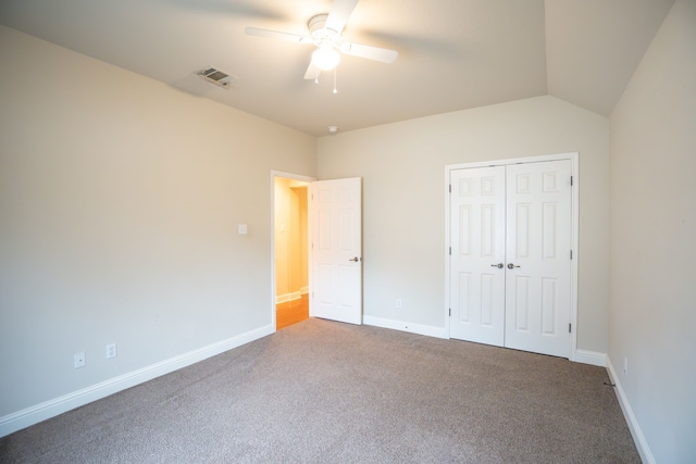 unfurnished bedroom with lofted ceiling, carpet flooring, ceiling fan, and a closet