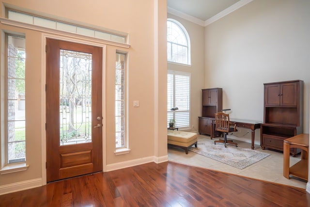 foyer entrance with crown molding and wood-type flooring