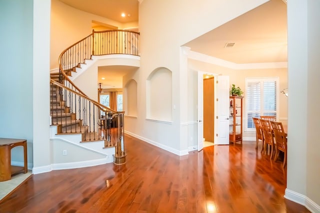 foyer with crown molding and hardwood / wood-style floors