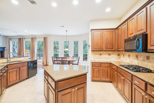 kitchen featuring decorative light fixtures, sink, decorative backsplash, black appliances, and light stone countertops