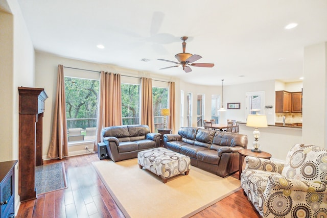 living room featuring hardwood / wood-style floors and ceiling fan