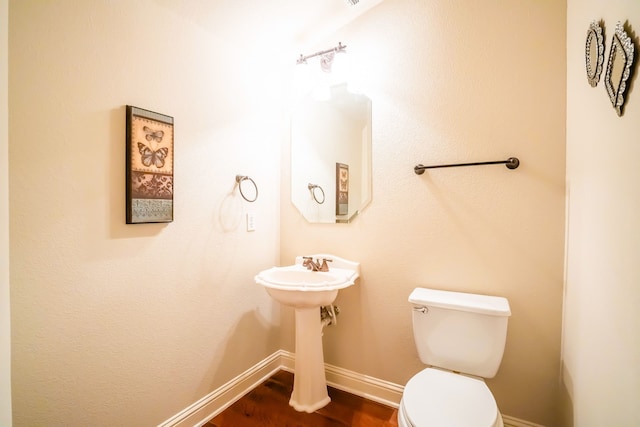 bathroom with wood-type flooring and toilet