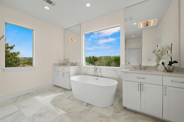 full bathroom featuring a wealth of natural light, visible vents, marble finish floor, and a sink