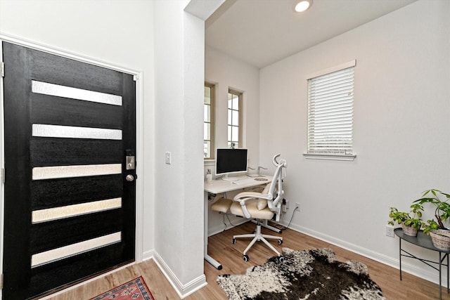 home office with light hardwood / wood-style flooring