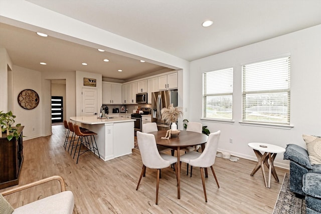 dining room featuring sink and light hardwood / wood-style floors