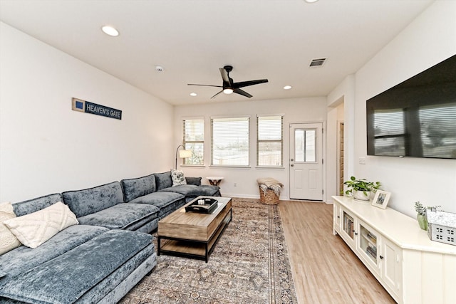 living room with light hardwood / wood-style flooring and ceiling fan