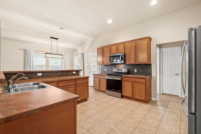 kitchen featuring decorative light fixtures, lofted ceiling, sink, backsplash, and stainless steel appliances