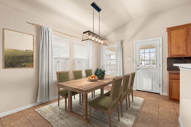 dining area with lofted ceiling and light tile patterned floors