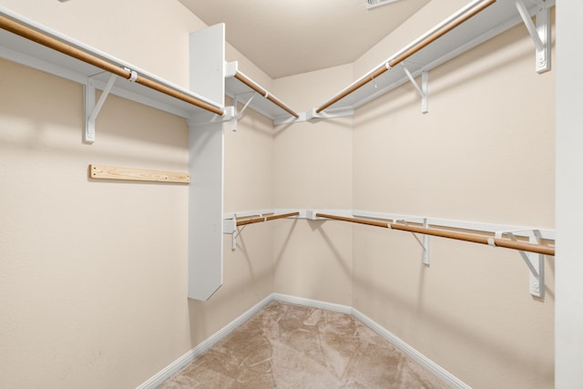 spacious closet featuring light colored carpet