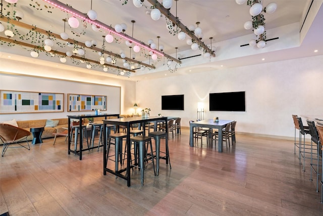 dining space featuring hardwood / wood-style flooring and a towering ceiling