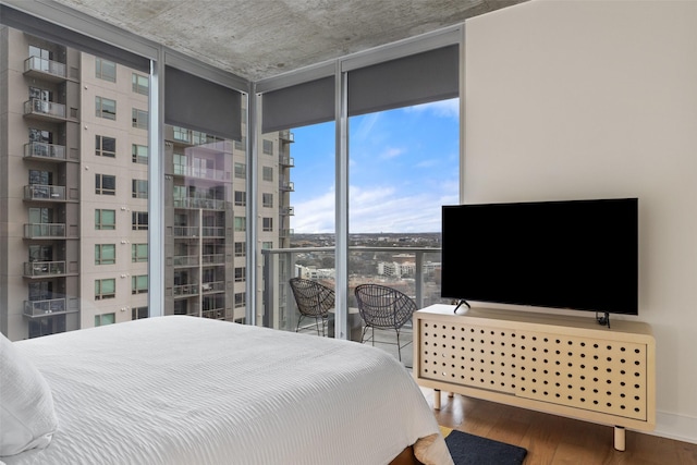 bedroom featuring hardwood / wood-style flooring and a wall of windows