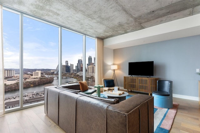 living room with a wall of windows and light hardwood / wood-style flooring