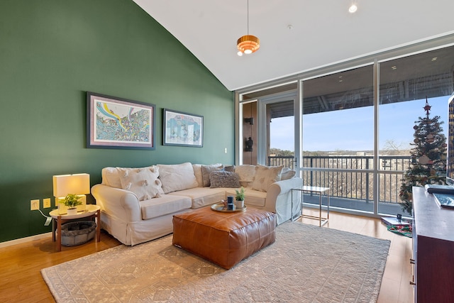 living room with hardwood / wood-style flooring, floor to ceiling windows, and vaulted ceiling