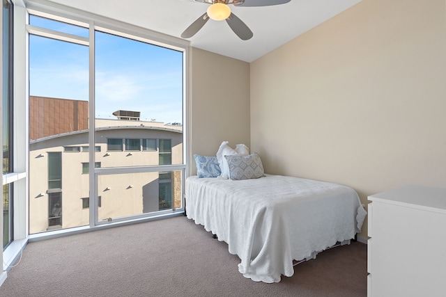 bedroom with a wall of windows, ceiling fan, and carpet