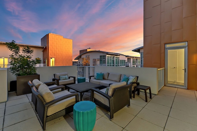 patio terrace at dusk with a balcony and outdoor lounge area