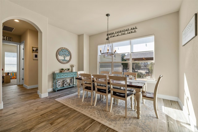 dining area with hardwood / wood-style flooring and a chandelier