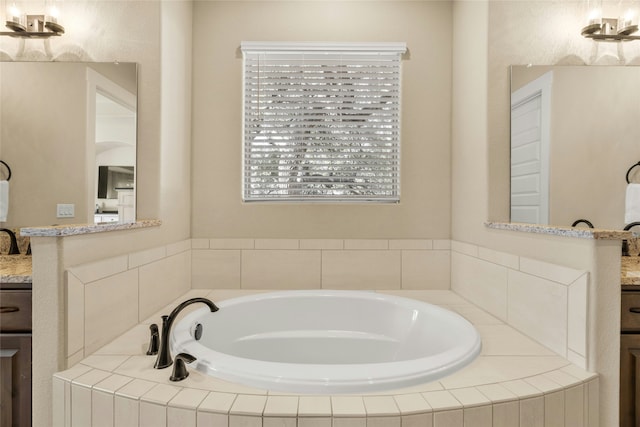 bathroom with vanity and tiled bath