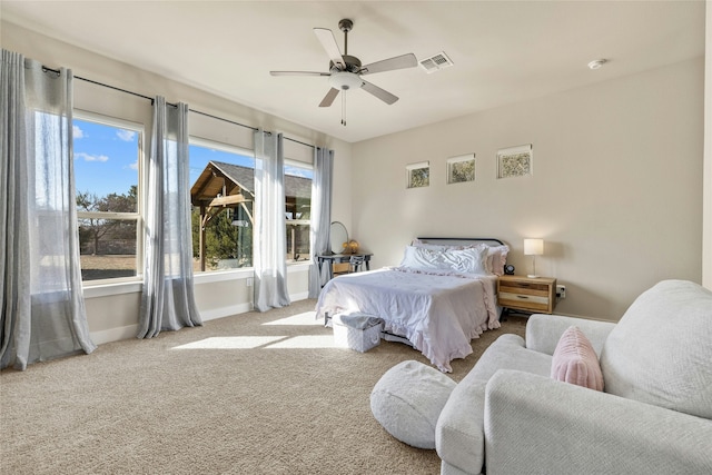 bedroom featuring multiple windows, light carpet, and ceiling fan