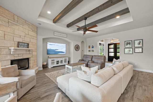 105 Aldea St, Georgetown, TX 78633 - living area featuring arched walkways, a fireplace, beamed ceiling, wood finished floors, and ceiling fan