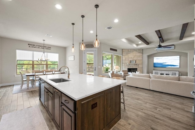 105 Aldea St, Georgetown, TX 78633 - kitchen with a fireplace, light wood-style floors, recessed lighting, a center island with sink, and a ceiling fan