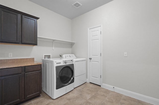 clothes washing area featuring cabinet space, baseboards, visible vents, and washing machine and clothes dryer