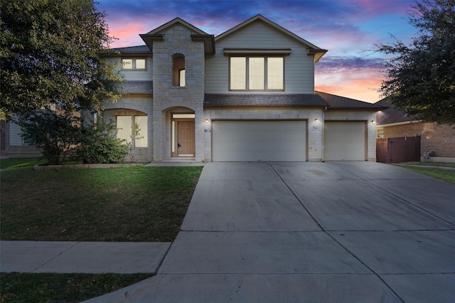 view of front of property with a garage and a lawn