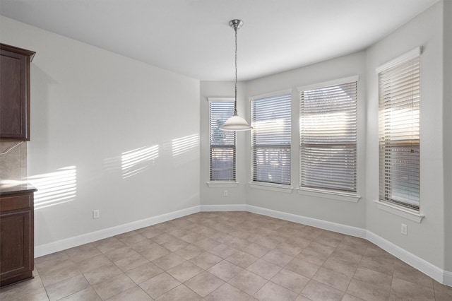 unfurnished dining area with baseboards