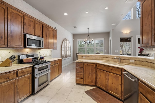 kitchen featuring sink, an inviting chandelier, hanging light fixtures, light tile patterned floors, and stainless steel appliances