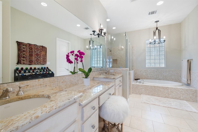 bathroom with an inviting chandelier, vanity, tile patterned flooring, and separate shower and tub