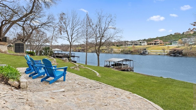 view of dock with a yard and a water view