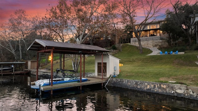 view of dock with a water view and a lawn