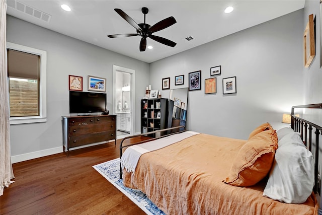 bedroom featuring ceiling fan, dark hardwood / wood-style flooring, and ensuite bath